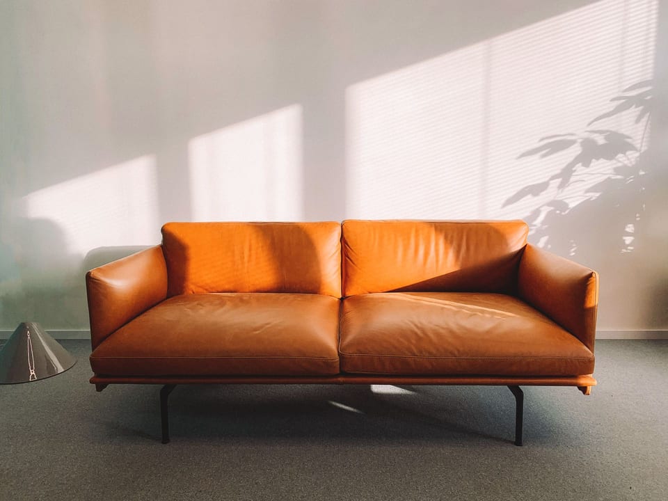 Fjord sofa — walnut frame, cognac leather, museum lighting